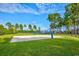 Outdoor sand volleyball court surrounded by lush green grass and tall pine trees at 3065 Moss Bridge Ln., Myrtle Beach, SC 29579
