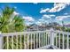 Balcony featuring white railings, scenic neighborhood views, and lush palm trees at 321 52Nd Ave. N, North Myrtle Beach, SC 29582