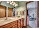 Bathroom featuring double sinks, wooden cabinetry, and a glimpse into an adjoining bedroom at 321 52Nd Ave. N, North Myrtle Beach, SC 29582