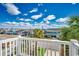 Bright balcony view showcasing coastal homes under a sunny, partly cloudy blue sky at 321 52Nd Ave. N, North Myrtle Beach, SC 29582