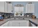 Kitchen featuring stainless appliances, double sink, mosaic tile backsplash, and bright natural light at 3700 Golf Colony Lane # 18-I, Little River, SC 29566