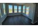 Bright sunroom with wood-look floors and three large windows overlooking the water at 4008 Bucolic Loop, Myrtle Beach, SC 29588