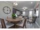 A dining area featuring a round wooden table with seating for four, open to the living room and showcasing modern light fixtures at 4035 Bucolic Loop, Myrtle Beach, SC 29588