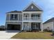 Charming two-story home boasts a welcoming front porch and a well-maintained lawn at 4035 Bucolic Loop, Myrtle Beach, SC 29588