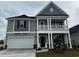 Two-story home with gray siding, white trim, a two-car garage and a covered porch at 4035 Bucolic Loop, Myrtle Beach, SC 29588