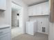 Well-lit laundry room with white cabinets, utility sink and a front-loading washing machine at 4035 Bucolic Loop, Myrtle Beach, SC 29588