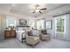 Cozy main bedroom featuring a tray ceiling, large windows, and comfortable seating area at 4035 Bucolic Loop, Myrtle Beach, SC 29588