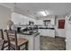 Efficient kitchen with white cabinets, black countertops, stainless steel appliances, and breakfast bar at 4291 Parkway Ln. # 4291, Little River, SC 29566