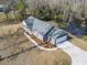 Aerial view of the gray home highlighting the driveway, garage, landscaping, and nearby pond at 4344 Jones Rd., Myrtle Beach, SC 29588