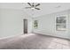 Bright bedroom featuring neutral carpet, ceiling fan, and natural light from two windows at 4344 Jones Rd., Myrtle Beach, SC 29588