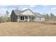 Charming gray home featuring an inviting front porch and a well-manicured lawn at 4344 Jones Rd., Myrtle Beach, SC 29588