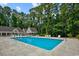Large community pool with inviting blue water, surrounded by shade trees, and lounge chairs at 4413 Eastport Blvd. # F-1, Little River, SC 29566