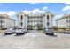 Condo exterior with palm trees, multiple levels, and assigned parking under sunny skies at 4413 Eastport Blvd. # F-1, Little River, SC 29566