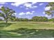 Scenic golf course view with a water hazard, green, and mature trees against a blue sky at 4413 Eastport Blvd. # F-1, Little River, SC 29566