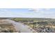 Scenic aerial view of waterway homes, golf course and pier under a partly cloudy sky at 4430 Eastport Blvd. # L5, Little River, SC 29566