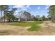 Expansive golf course view of the community with condos in the background on a sunny day at 4430 Eastport Blvd. # L5, Little River, SC 29566