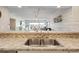 A stainless steel double sink in the kitchen looks through to the living room with balcony access at 4440 Nassau Ct. # 502, Little River, SC 29566