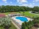 Aerial shot showcasing a community pool with lounge chairs, mature trees, and covered seating at 4440 Nassau Ct. # 502, Little River, SC 29566