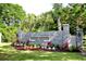 Entrance to Coquina Harbour with landscaped flowerbed, stone wall, and palm trees at 4440 Nassau Ct. # 502, Little River, SC 29566