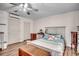 Cozy bedroom features light wood-look floors, a ceiling fan, comfortable furniture, and ample natural light at 451 Holly View Ln., Loris, SC 29569