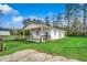 Exterior view of white outbuilding with blue trim, surrounded by green grass and mature trees at 451 Holly View Ln., Loris, SC 29569