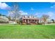 Sprawling brick home with a large front yard, mature trees, and a welcoming front porch at 451 Holly View Ln., Loris, SC 29569