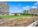Expansive rural property featuring a home, outbuildings, a large field, and blooming trees at 451 Holly View Ln., Loris, SC 29569