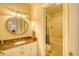 Well-lit bathroom with marble countertop, decorative mirror, and bathtub at 4514 Wagon Run Circle, Murrells Inlet, SC 29576