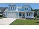 Charming two-story blue home featuring a spacious front yard and attached two-car garage at 5023 Middleton View Dr., Myrtle Beach, SC 29579