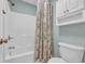 Bright bathroom featuring a bathtub with a shower, toilet, and a wall-mounted storage cabinet at 503 20Th Ave. N # 45D, North Myrtle Beach, SC 29582