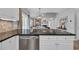 Modern kitchen with white cabinets, stainless steel appliances, and a view of the living room at 503 20Th Ave. N # 45D, North Myrtle Beach, SC 29582