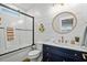 Bathroom featuring shiplap walls, blue vanity, and a glass-enclosed tub and shower at 5100 Ocean Blvd. N, North Myrtle Beach, SC 29582