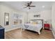 Cozy bedroom with a ceiling fan, wood floors, large window, and bright red nightstands at 5100 Ocean Blvd. N, North Myrtle Beach, SC 29582