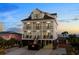Beautiful three-story beach house with balconies, dark metal roof, and an American flag waving in the breeze at 5100 Ocean Blvd. N, North Myrtle Beach, SC 29582