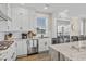 Well-lit kitchen with stainless steel refrigerator, white cabinets and marble countertops at 5100 Ocean Blvd. N, North Myrtle Beach, SC 29582