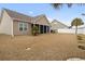 A partial backyard view of the home featuring a screened porch and manicured lawn with young palm trees at 545 Tourmaline Dr., Little River, SC 29566