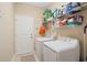 Functional laundry room features a washer, a dryer, shelving and tile flooring at 545 Tourmaline Dr., Little River, SC 29566