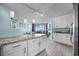 Bright kitchen featuring granite countertops, white cabinetry, and opening to living room with balcony access at 5523 N Ocean Blvd. # 1101, Myrtle Beach, SC 29577