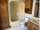 Bathroom featuring tub and shower combo, wooden storage cabinets, and a white tile floor at 5704 Woodside Ave., Myrtle Beach, SC 29577