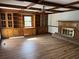 Living room with built-in cabinets, wood floors, brick fireplace, and exposed wood ceiling beams at 5704 Woodside Ave., Myrtle Beach, SC 29577