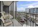 A spacious balcony with seating, overlooking a parking area and offering ocean views beyond a building at 5905 S Kings Highway # 416-A, Myrtle Beach, SC 29575