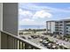 Balcony view overlooking parking area with ocean backdrop on a sunny day at 5905 S Kings Highway # 416-A, Myrtle Beach, SC 29575
