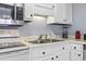 This kitchen has stainless steel microwave and double sinks under the bright cabinet lighting at 5905 S Kings Highway # 416-A, Myrtle Beach, SC 29575