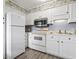 Efficient kitchen features white cabinets, appliances, and eye-catching beach-themed wallpaper at 5905 S Kings Highway # 416-A, Myrtle Beach, SC 29575