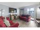 Cozy living room with red couches, wood floors, and balcony access at 5905 S Kings Highway # 416-A, Myrtle Beach, SC 29575