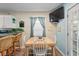 Inviting dining area featuring wood table and white chairs, with a mounted TV and bright natural light at 6001- 1222 S Kings Highway, Myrtle Beach, SC 29575