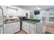 Well-lit kitchen with white cabinets, green countertops, and a breakfast bar overlooking the dining area at 6001- 1222 S Kings Highway, Myrtle Beach, SC 29575