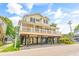 Attractive two-story beach house elevated on sturdy supports, featuring a welcoming porch and ample ground-level parking and storage at 6001 - Mh69B South Kings Hwy., Myrtle Beach, SC 29575