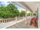 Covered porch overlooking a tree-filled landscape, featuring white railings and posts, with chairs for relaxation at 6001 - Mh69B South Kings Hwy., Myrtle Beach, SC 29575