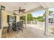 Covered porch features a wooden floor, ceiling fans, a black patio dining set, and a scenic view at 6001 - Mh69B South Kings Hwy., Myrtle Beach, SC 29575